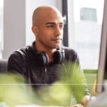 A man in an office is having a lovely time thinking about Kubernetes