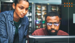 Two people look intently at a computer screen