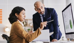 A man and a woman are discussing what they see on a computer screen