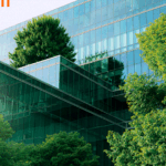 Glass office block with greenery and plants growing around it