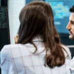 Two people looking at a computer screen solving customer issues