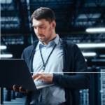 A man searches on his laptop for information on AWS and observability.